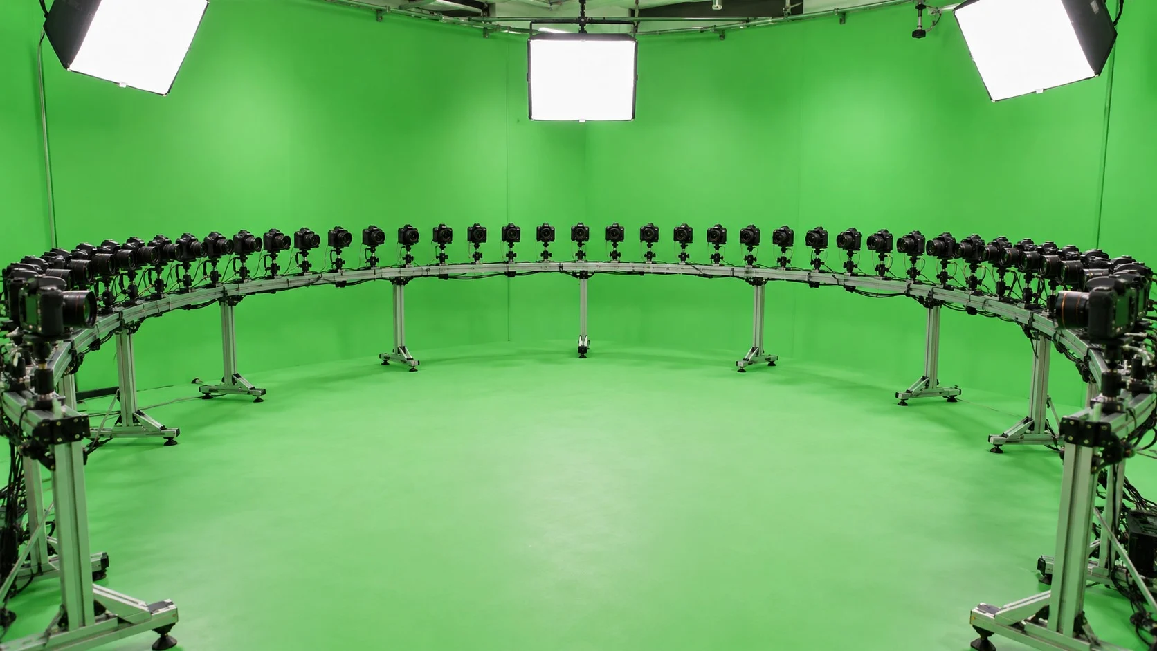 Trong một studio phông xanh sáng sủa, hàng chục máy ảnh nhỏ giống hệt nhau được gắn cạnh nhau dọc theo một khung kim loại uốn cong, vây tròn quanh khoảng trống ở giữa