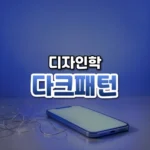 다크패턴 썸네일: 화면 아래쪽 밝은 책상에 빈 화면의 스마트폰과 가는 은색 실 뭉치가 놓이고 남색 빛이 위로 번져 가운데·위쪽에 글자를 올릴 여백이 있는 모습
