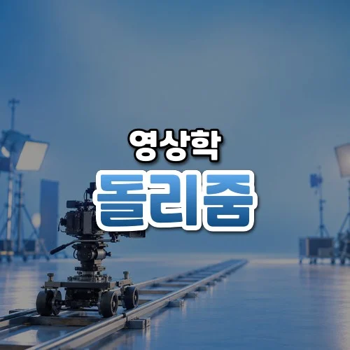 돌리줌 썸네일: 아래쪽 레일 위에 돌리에 올린 영화 카메라가 있고 가운데·위로 글자를 올릴 푸른 여백이 넓은 모습