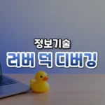 러버 덕 디버깅 썸네일: 화면 아래쪽 밝은 나무 책상에 노란 고무 오리와 노트북 자판 끝이 놓여 있고, 남색 빛이 위로 번져 가운데·위쪽에 글자를 올릴 여백이 있는 모습