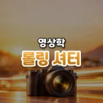 롤링 셔터 썸네일: 화면 아래쪽에 작은 카메라가 정면을 향하고 뒤로 가로 빛줄기가 지나가며, 호박색 빛이 위로 번져 글자를 올릴 여백이 있는 모습
