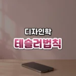 테슬러법칙 썸네일: 장밋빛 낮빛이 도는 벽 아래 밝은 나무 책상에 스마트폰 한 대가 놓여 있고 위쪽은 글자를 올릴 여백이 넓은 모습
